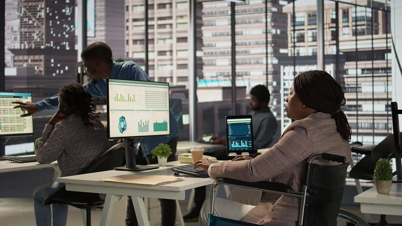 Чернокожий менеджер, пользующийся инвалидной коляской, проверяет финансовые данные для ежемесячных отчетов.