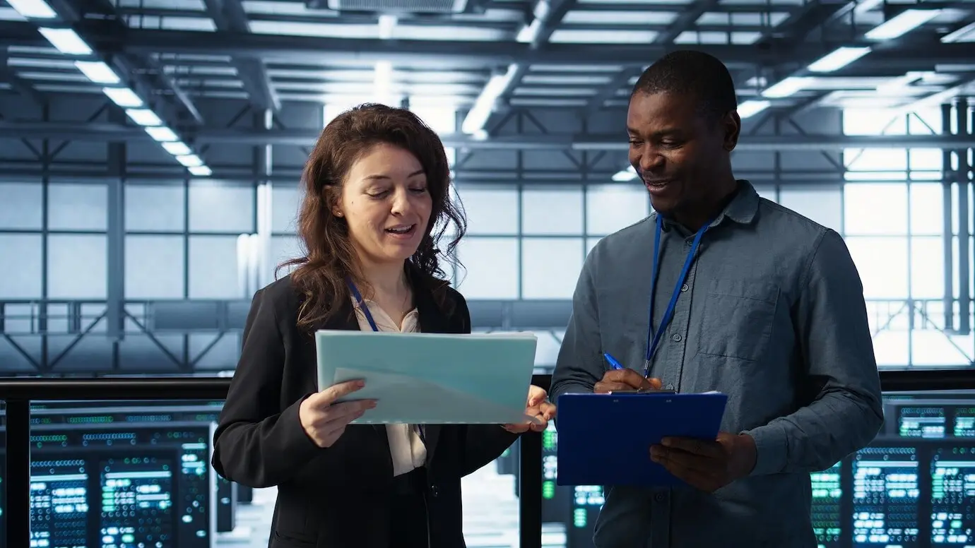 Руководители управления центром обработки данных читают бумажные документы.